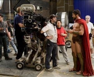 Diretor Zack Snyder parece pequeno ao lado do Leônidas, passando um script.