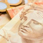 Real - Brazilian Currency. Money, Dinheiro, Brasil, Reais. A group of Real bills and Real coins on a table.